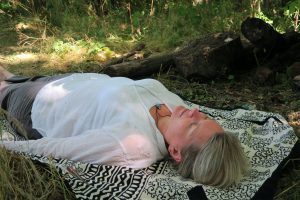 woman relaxing in a woodland shinrin-yoku