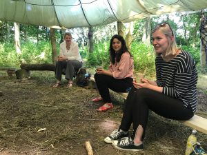 people sitting around a campfire parachute drinking coffee and chatting happily